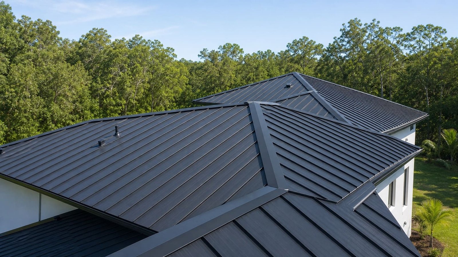 The same home under a charcoal standing-seam metal roof with clean panel runs